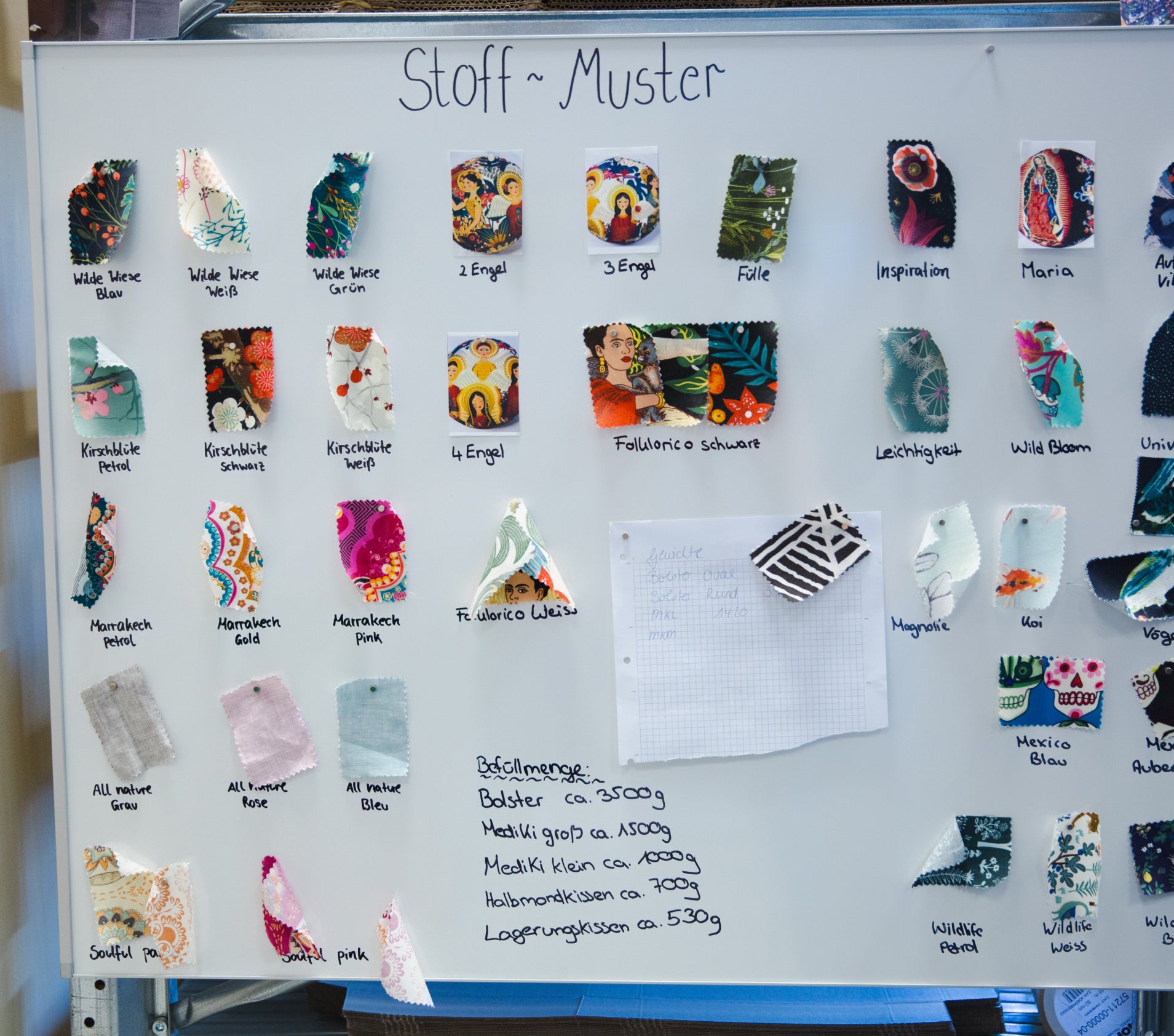 Verschiedene Stoffmuster an einer Pinnwand befestigt.